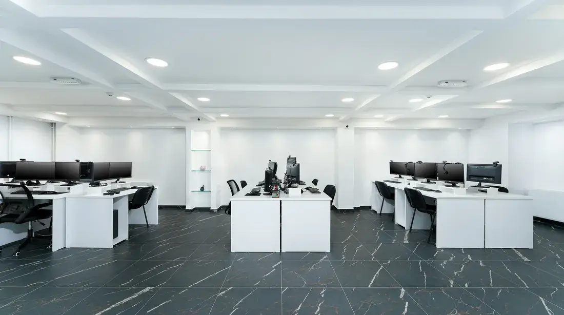 An open plan floor of workstations at the MakBPO office in Bitola, with rows of desks and dual monitors.
